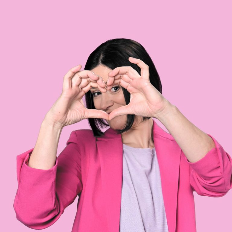 Humorvolle Frau zeigt Herz in die Luft mit den Händen