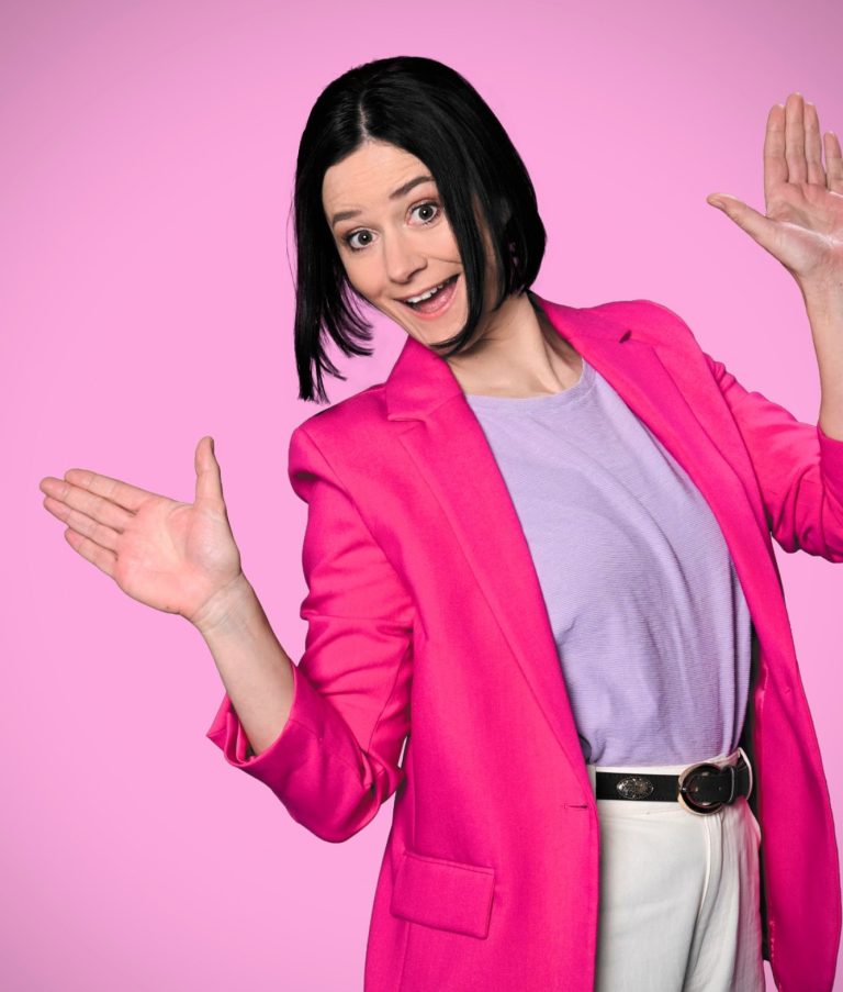 Frau sehr fröhlich im pinken Blazer